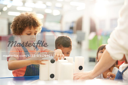 Curious kids playing with large dominos in science center