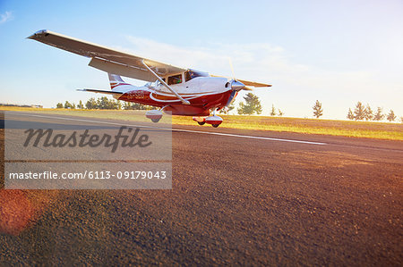 Prop airplane landing on sunny tarmac