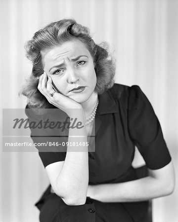 1940s WOMAN LOOKING AT CAMERA WITH A SAD DISGRUNTLED PAINED SICK FACIAL EXPRESSION
