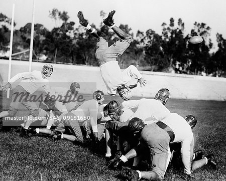 1930s 1940s LEATHER HELMET ERA FOOTBALL SCRIMMAGE LINE ONE PLAYER UPSIDE DOWN IN MIDAIR