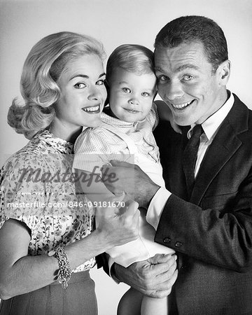 1960s PORTRAIT SMILING FAMILY OF THREE BOY TODDLER MOTHER FATHER LOOKING AT CAMERA