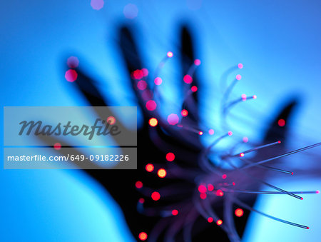 Digital age: artificial intelligence fibre optics carrying data passing through hand