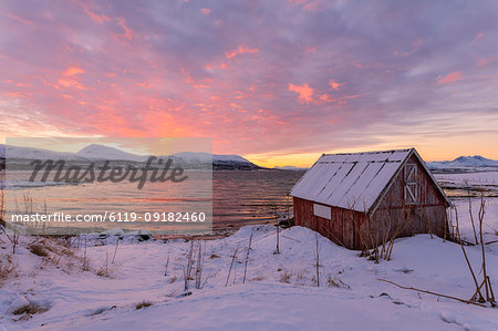 Wood hut by the sea at sunset, Troms, Norway, Scandinavia, Europe