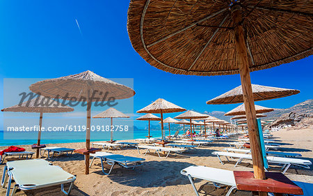 Umbrellas on the beach and emerald seas at Falassarna beach in Western Crete, Greek Islands, Greece, Europe