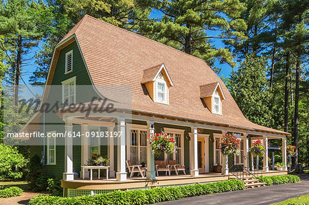 1920s house with green cedar wood shingle siding and white trim bell roof