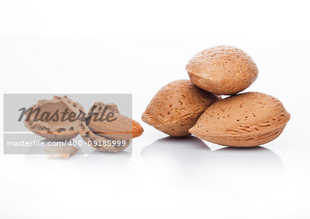 Raw almonds nuts with shell on white background with reflection