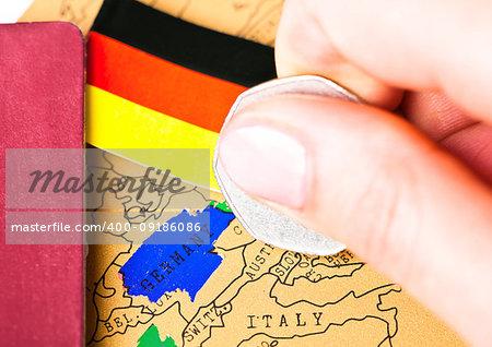 Travel holiday to Germany concept with passport and flag with female hand choosing Germany on the map