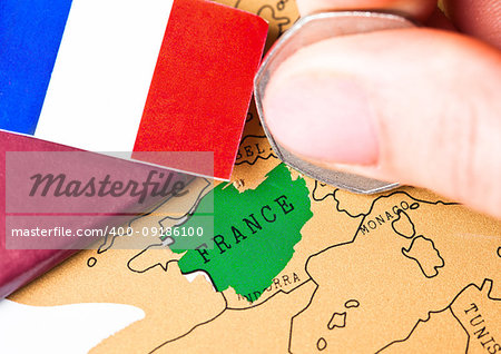 Travel holiday to France concept with passport and flag with female hand choosing France on the map