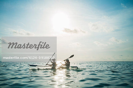 Women in clear bottom canoe on sunny, idyllic ocean, Maldives, Indian Ocean
