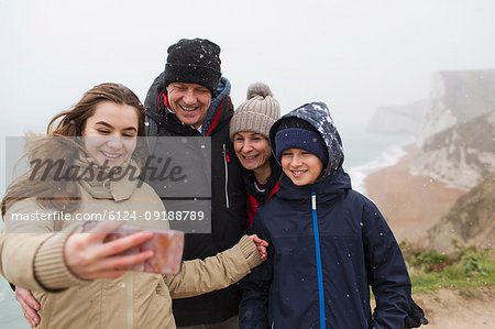 Snow falling over family taking selfie with camera phone