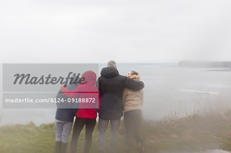 Family in warm clothing enjoying ocean view