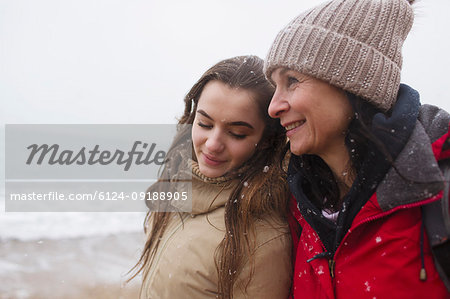 Affectionate mother and daughter on snowy winter beach