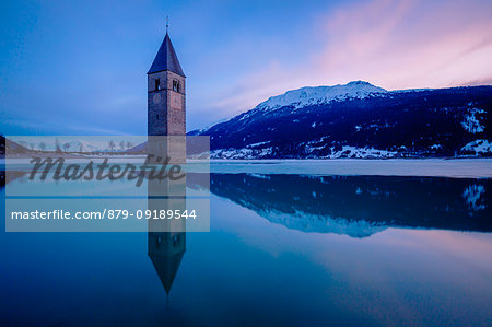 The bell-tower of Graun in Vinschgau at dusk, Reschensee - Lago di Resia, Bolzano, South Tyrol, Trentino Alto Adige, Italy