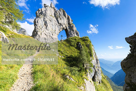 A path leads to Porta di Prada, a rock natural arch in the Grigna group. Grigna Settentrionale(Grignone), Northern Grigna Regional Park, Lombardy, Italy, Europe. A path leads to Porta di Prada, a rock natural arch in the Grigna group. Grigna Settentrionale(Grignone), Northern Grigna Regional Park, Lombardy, Italy, Europe.
