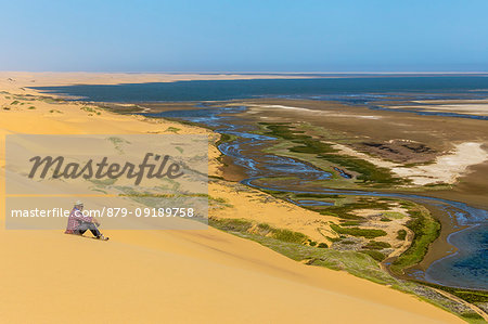 Man admiring the ocean from the top of the sand dunes,Sandwich Harbour,Namib Naukluft National Park,Namibia,Africa
