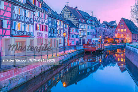 Canal waterfront view of traditional townhouses at dusk, Colmar, France