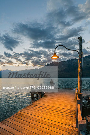 Man and child on the jetty at dusk. Glenorchy, Queenstown Lake district, Otago region, South Island, New Zealand.