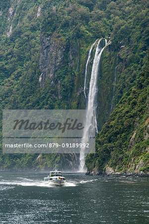 Touristic boat and Stirling Falls in Milford Sound. Fiordland NP, Southland district, Southland region, South Island, New Zealand.