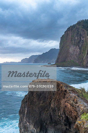 Person on a cliff watching the sunrise. Faial, Santana municipality, Madeira region, Portugal.