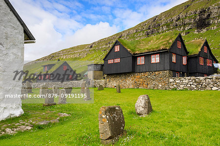 Traditional houses with grass roof and cemetery, Kirkjubour, Streymoy island, Faroe Islands, Denmark