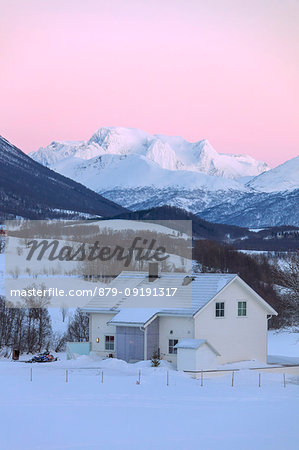 Sunrise on typical house with Lyngen Alps in the background, Mestervik, Troms county, Norway