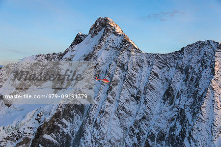 Helicopter in flight on the north face of Monte Disgrazia, Valmalenco, Val Masino, Valtellina, Lombardy, province of Sondrio, Italy