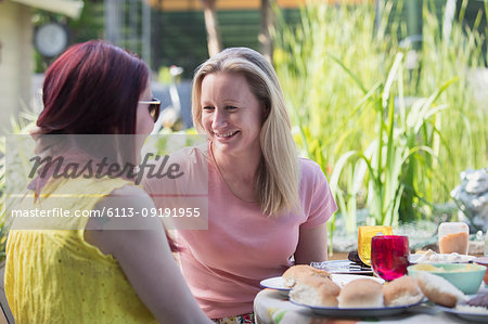 Affectionate lesbian couple enjoying lunch on patio