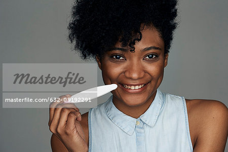 Close-up of young woman holding pregnancy test strip