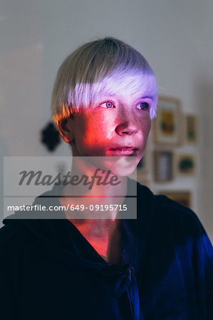 Woman daydreaming, red light reflected on face