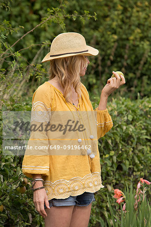 Woman eating apple from garden