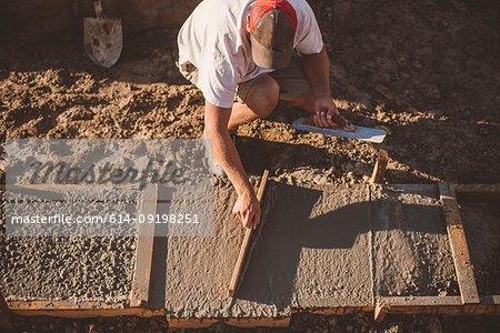 Builder laying cement foundation