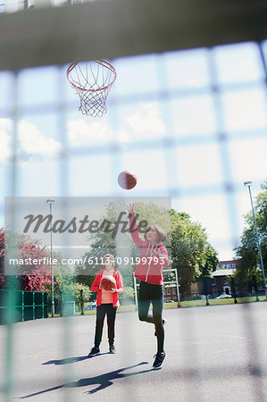 Active senior women playing basketball in sunny park