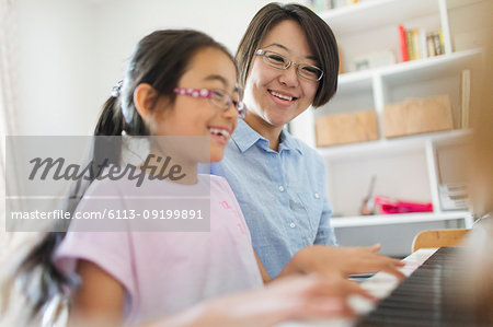 Mother and daughter playing piano