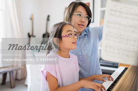 Mother and daughter playing piano