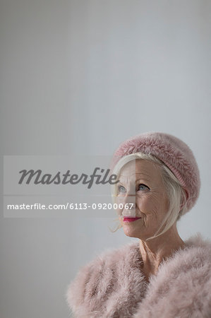 Portrait confident, elegant senior woman wearing pink fur