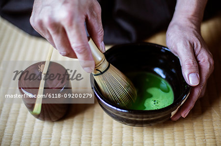 High angle close up of traditional Japanese Tea Ceremony, man using bamboo whisk to prepare Matcha tea.