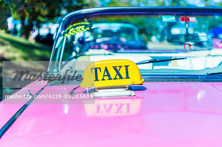 A taxi sign on a classic American car used as a taxi in Varadero, Cuba, West Indies, Caribbean, Central America