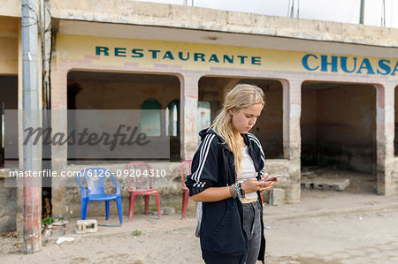 Woman texting outside of restaurant in Atitlan, Guatemala