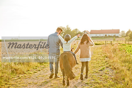 Parents walking with child on horse in Sweden