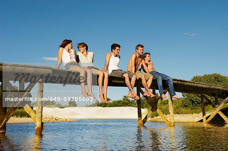 Group of young people sitting on jetty