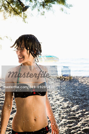 Woman standing in shower at beach