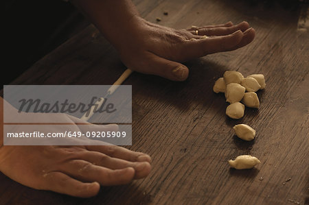 Cook rolling gnocchi dough in kitchen