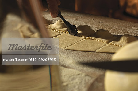 Close up of cook cutting ravioli dough