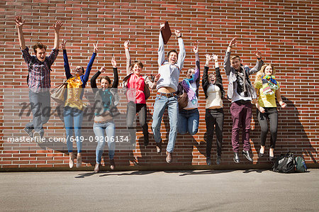 Friends jumping for joy on city street
