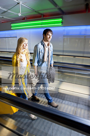 Couple on moving walkway in airport