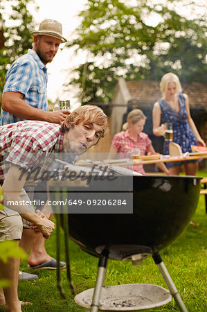 Man grilling fish on barbecue outdoors