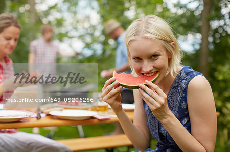 Woman eating watermelon outdoors