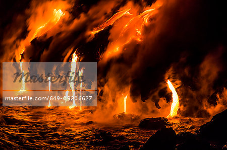 Lava flowing over cliff into water