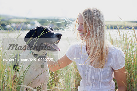 Woman with dog by coast, Wales, UK