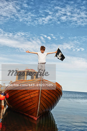 Portrait of boy on boat holding pirate flag, Eggergrund, Sweden